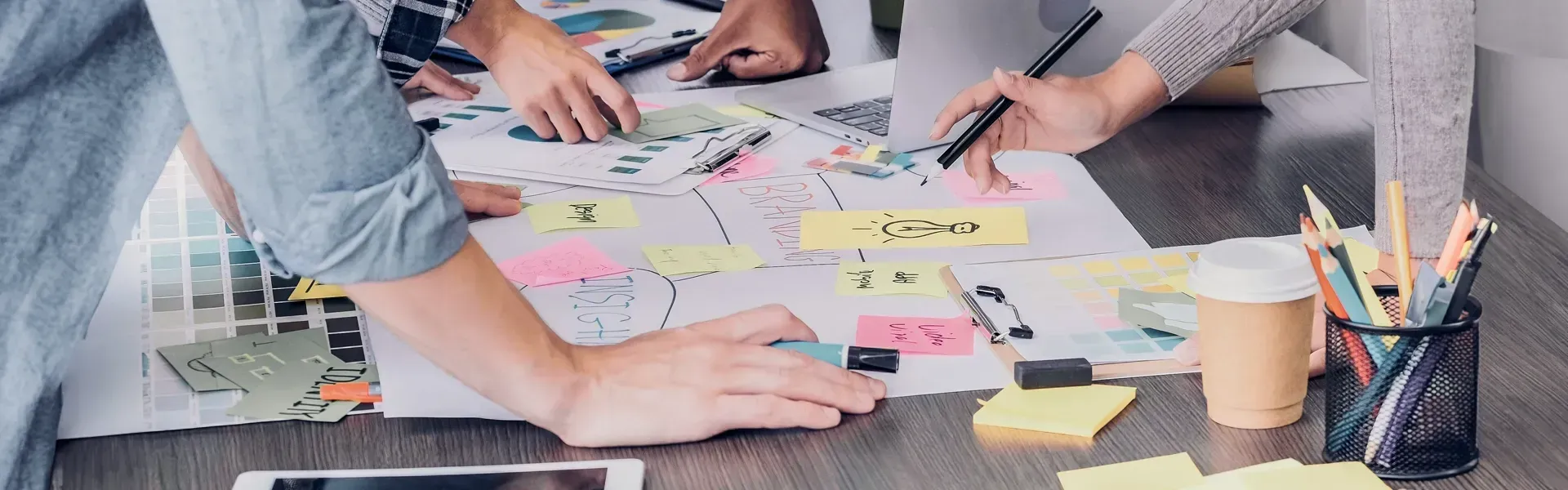 Employees gathered around a desk filled with paper