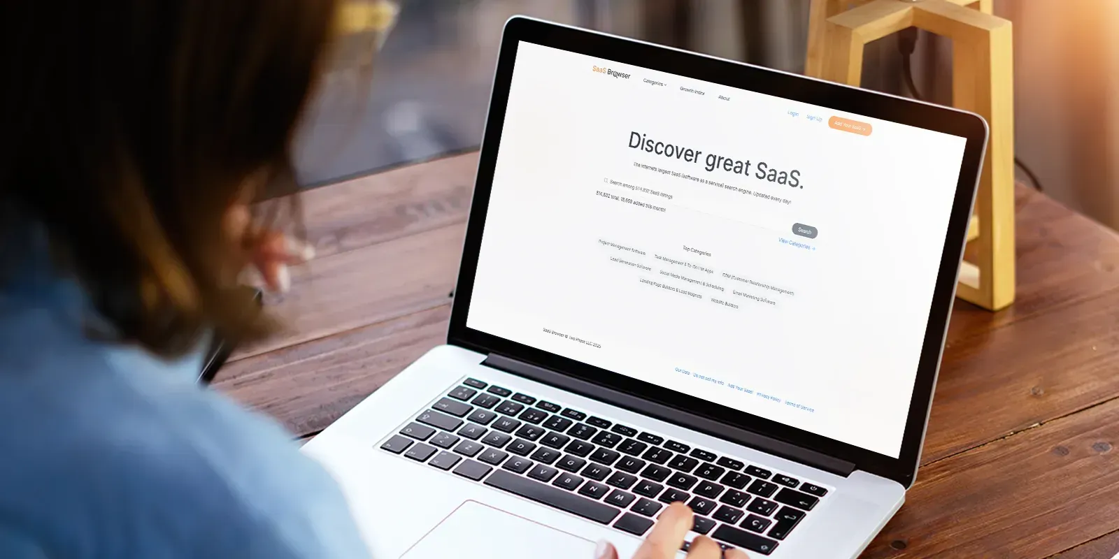 Person looking at laptop screen with saasbrower.com webpage on screen