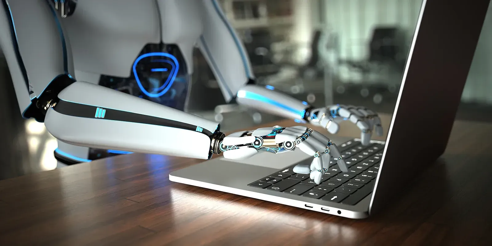 Robot using a laptop, typing with metallic fingers on a wooden desk.