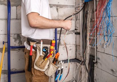A man is working on electrical wires in a room.