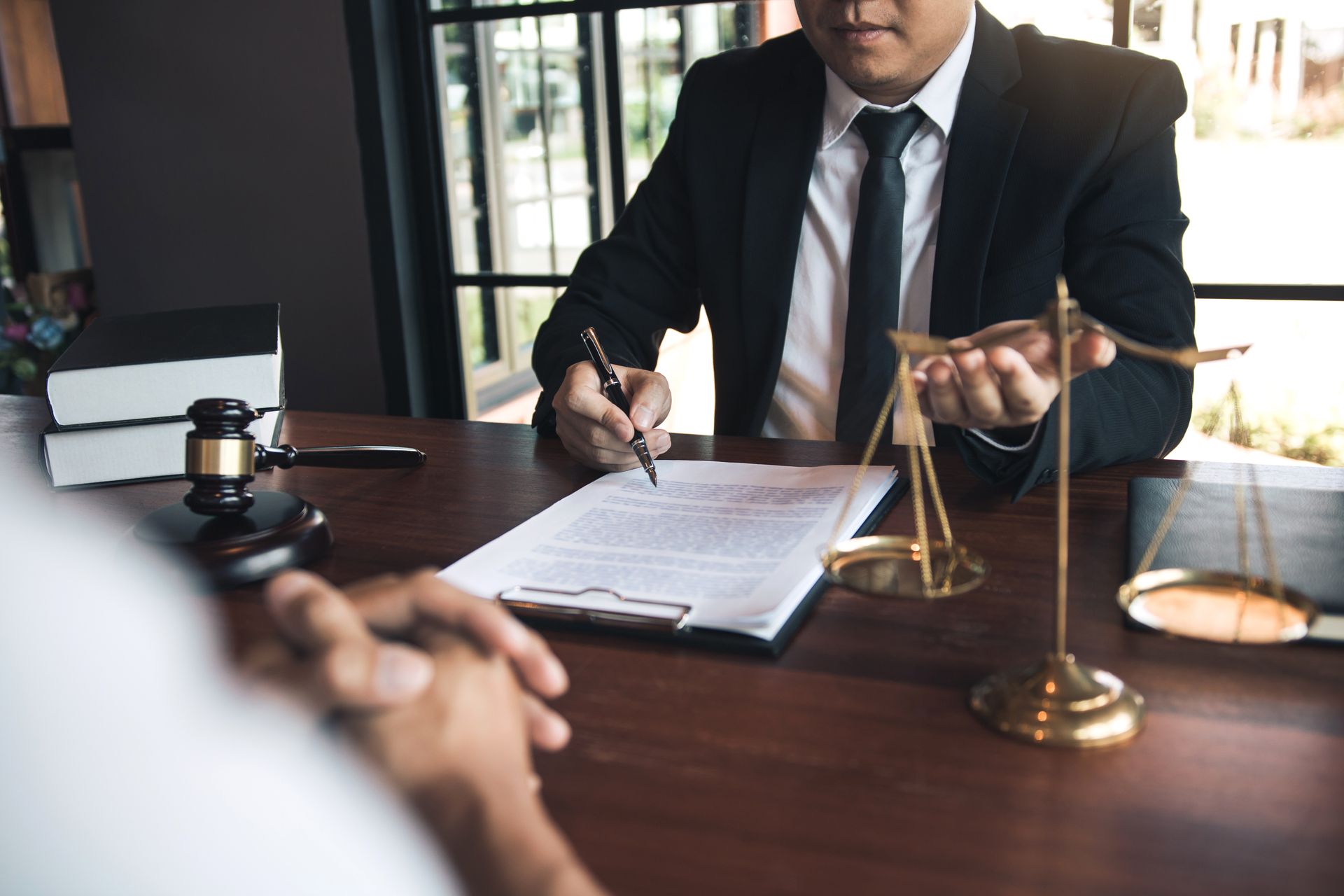 A lawyer is sitting at a desk talking to a client.