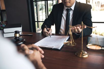 A lawyer is sitting at a desk talking to a client.