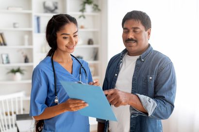 A nurse is looking at a clipboard with a patient.