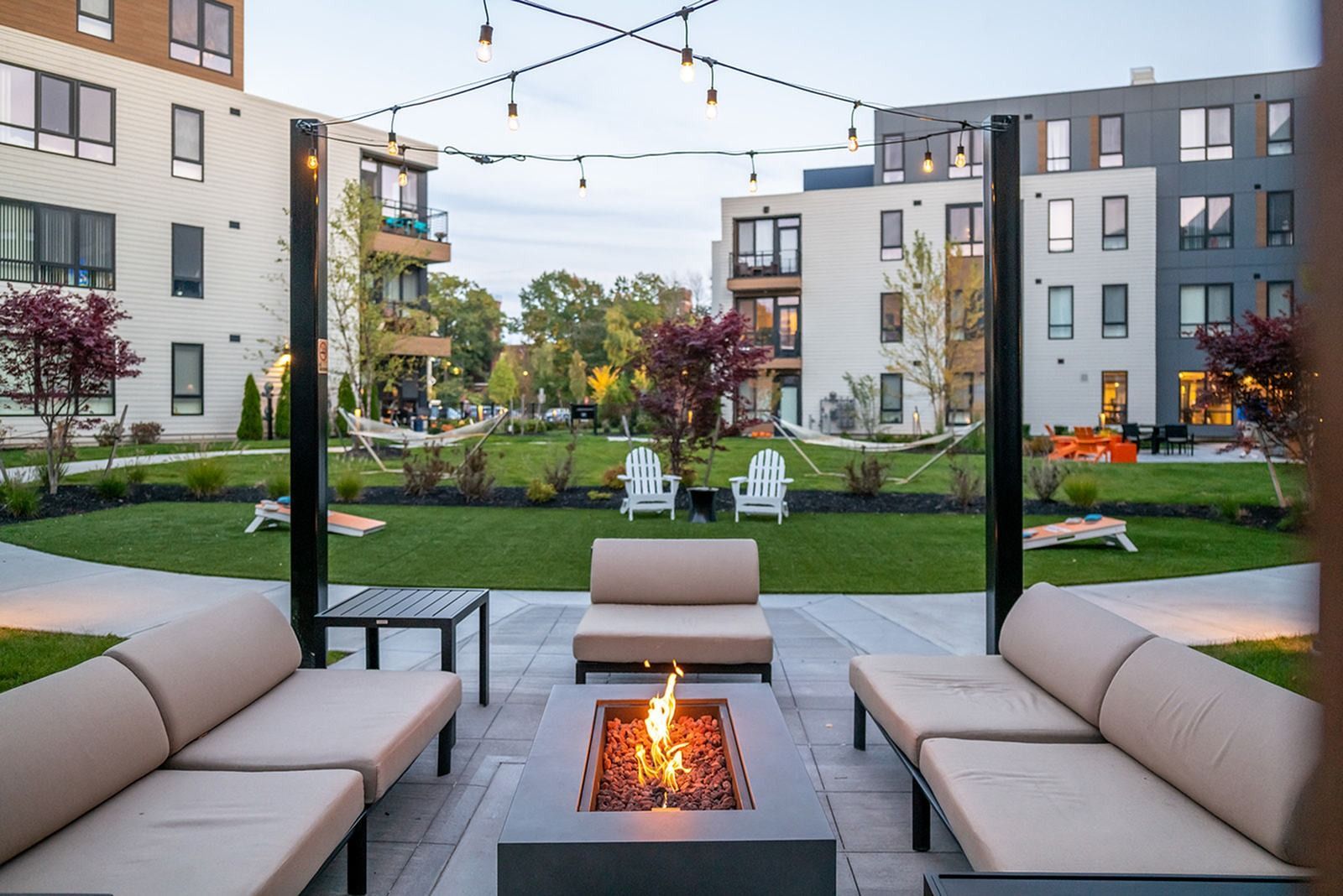 West End Yards outdoor lounge with fire pit and green lawn.