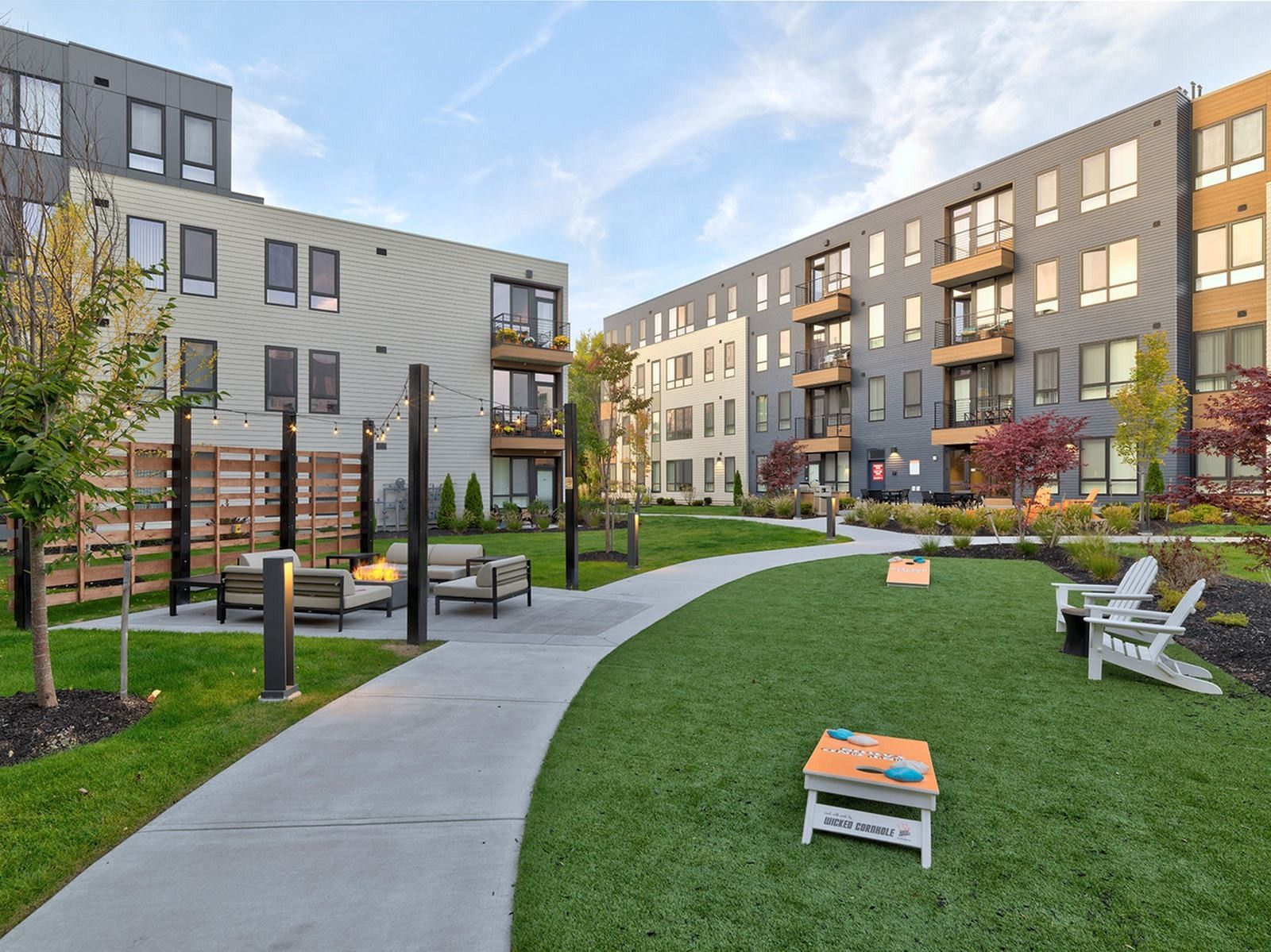 West End Yards outdoor area with walking path, chairs, and cornhole game.