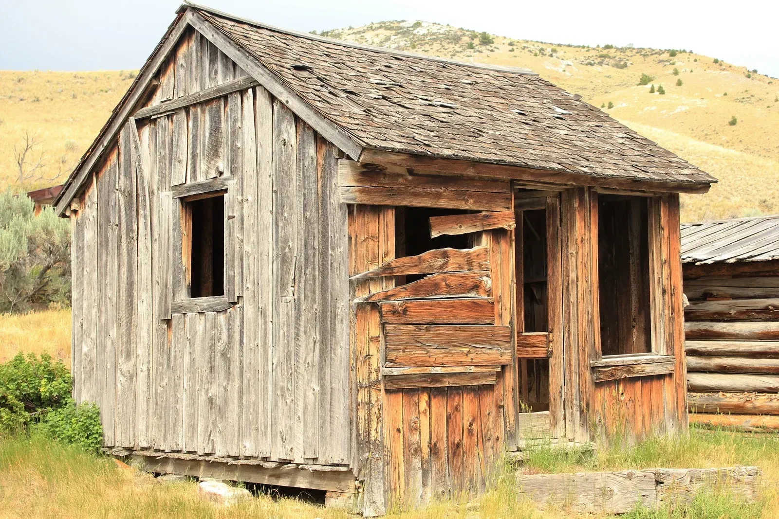 An old wooden house in the middle of a field