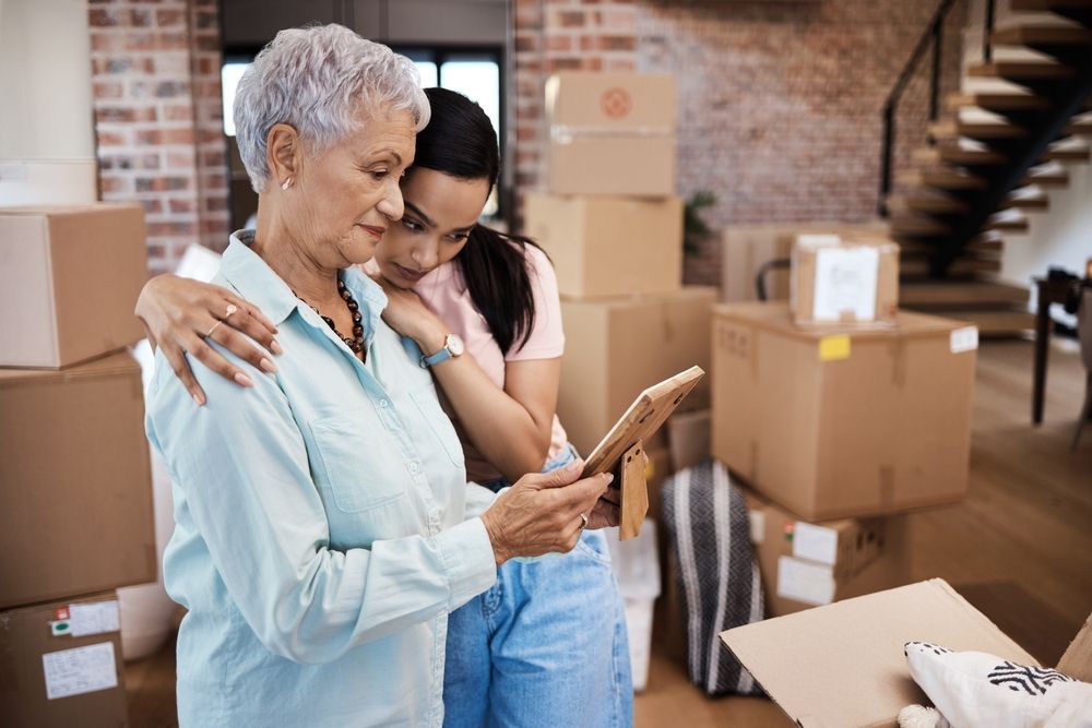 Every home has a history. Shot of a senior woman looking at a photograph with her daughter while packing boxes on moving day.
