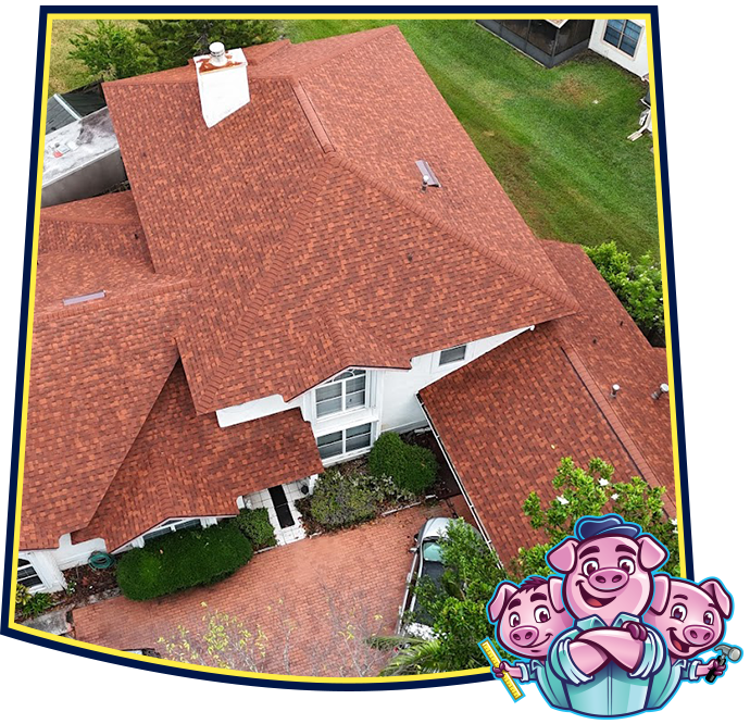 An aerial view of a house with a red shingled roof, accented by a cartoon graphic of three pigs.