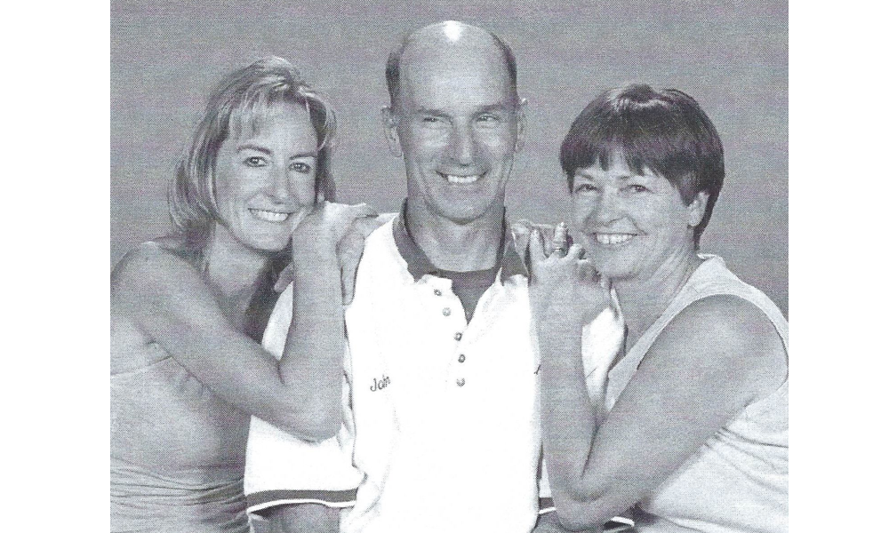 A man and two women are posing for a picture together.