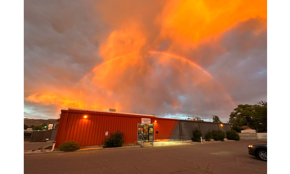 A building with a rainbow in the sky above it.