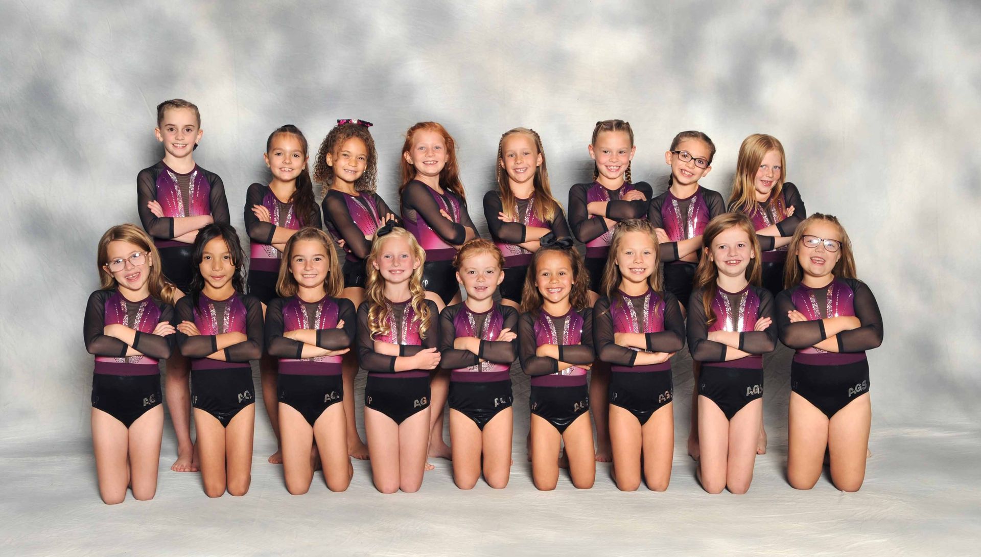 A group of young girls posing for a picture with their arms crossed