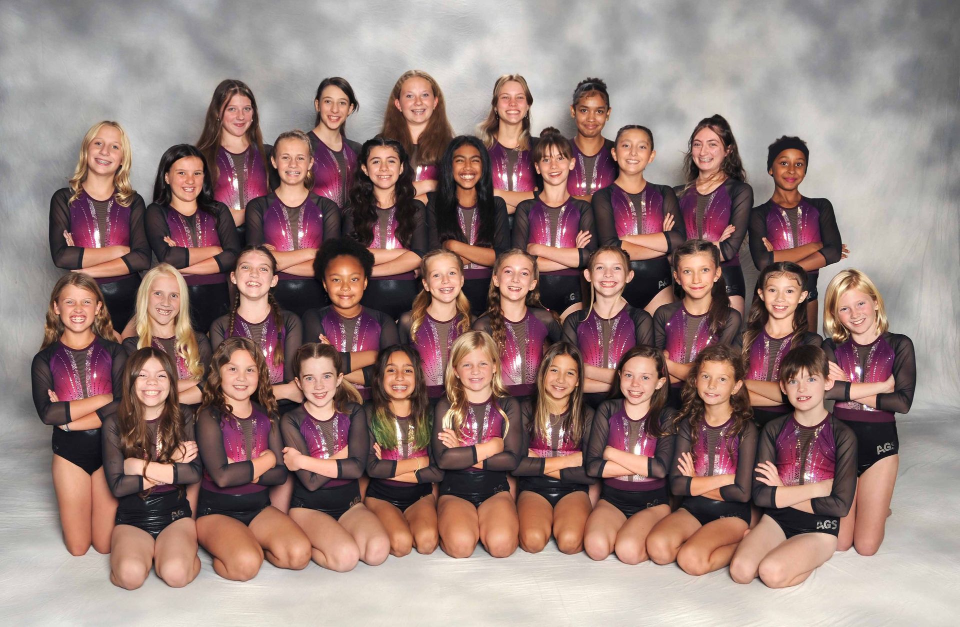 A group of young girls posing for a picture with their arms crossed