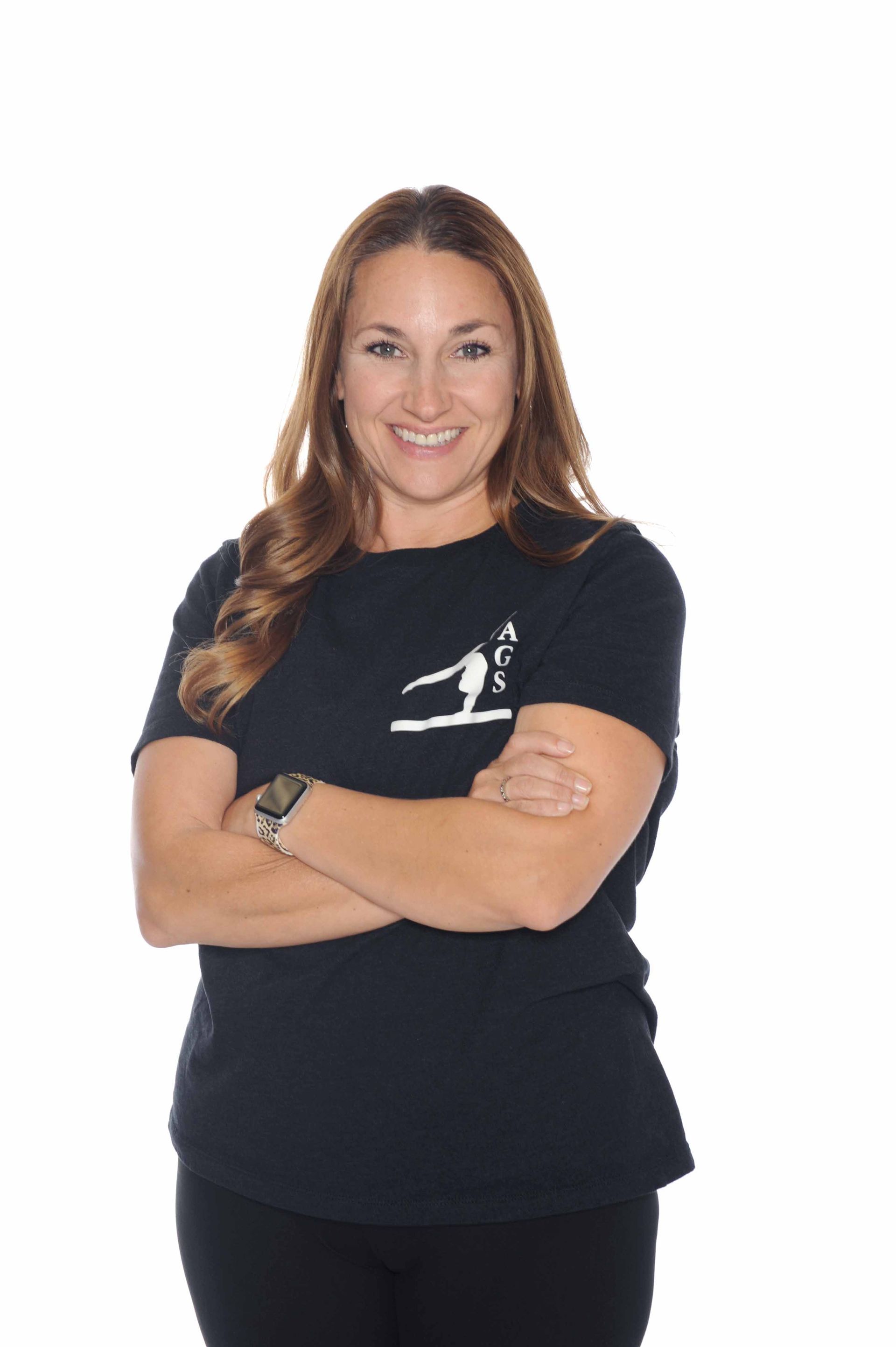 A woman in a black shirt is standing with her arms crossed.