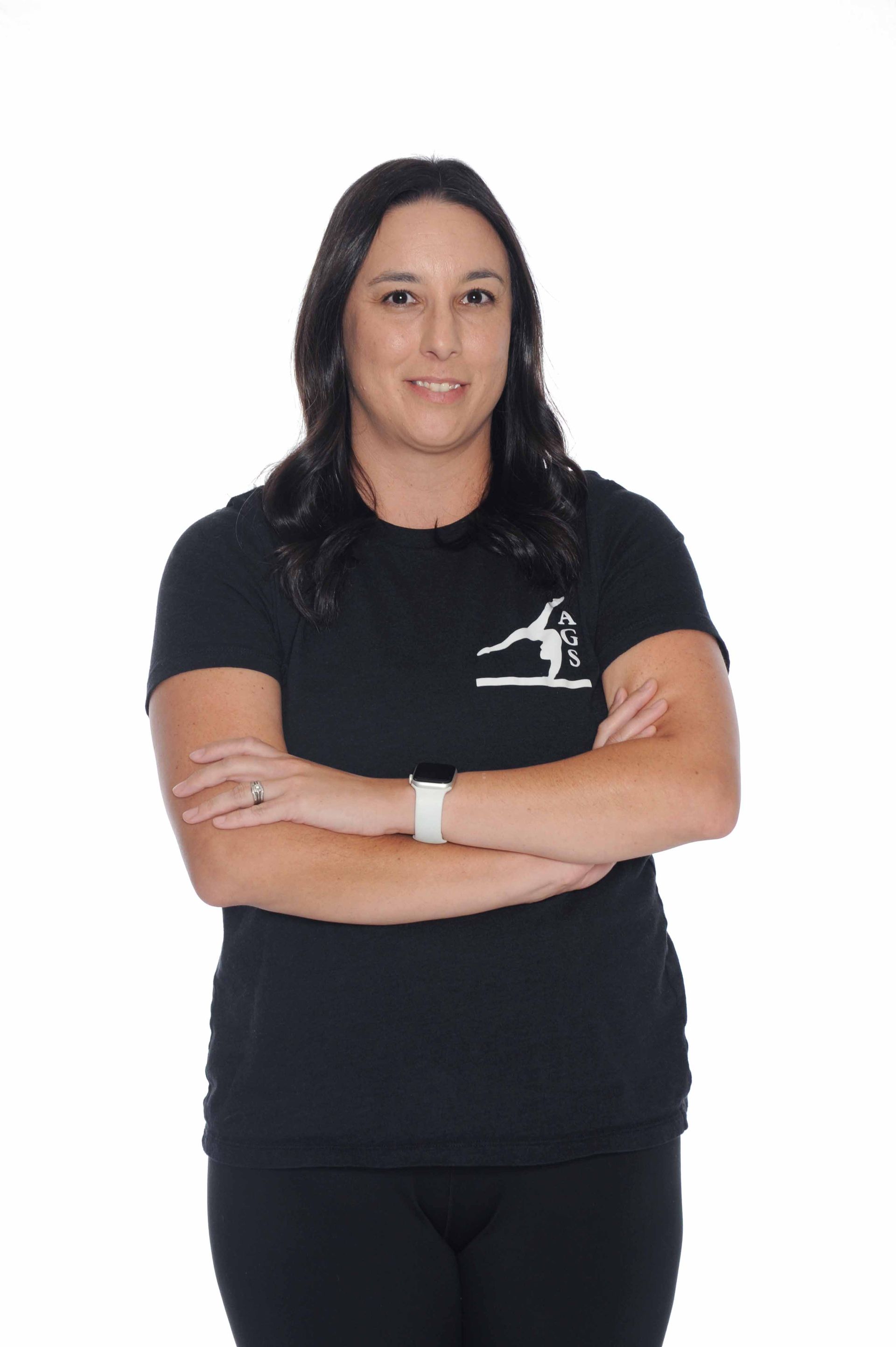 A woman in a black shirt is standing with her arms crossed.