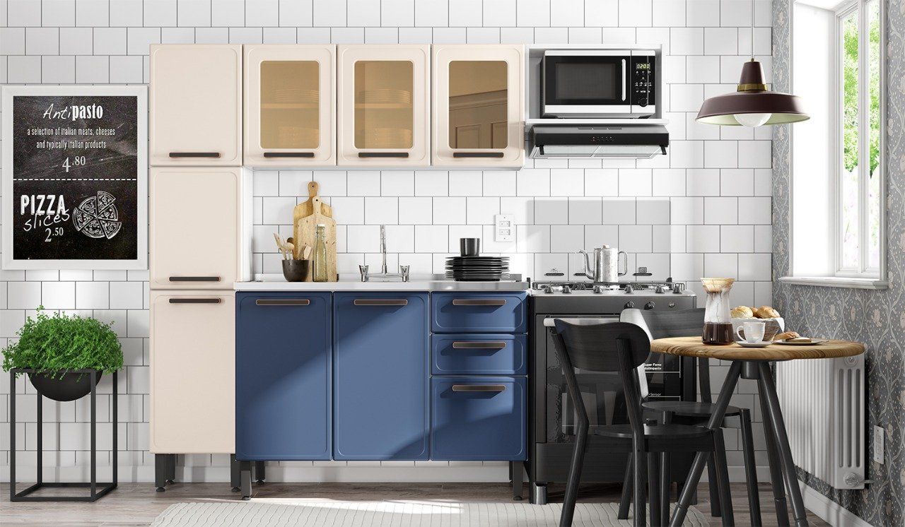 Una cocina con gabinetes azules, una estufa, un microondas, una mesa y sillas.