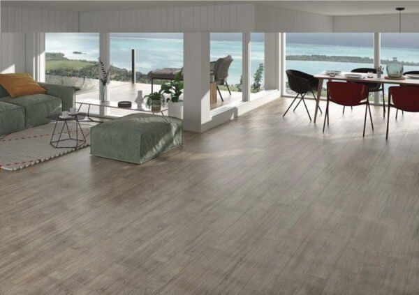 Una sala de estar con sofá, mesa y sillas y vista al océano.