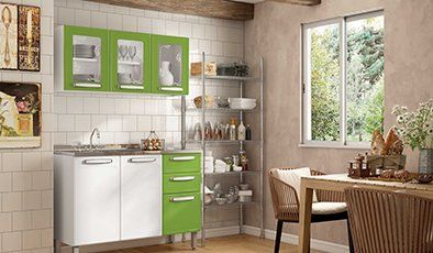 Una cocina con gabinetes verdes, un fregadero, una mesa y sillas.