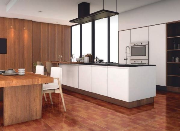 Una cocina con gabinetes blancos y pisos de madera.