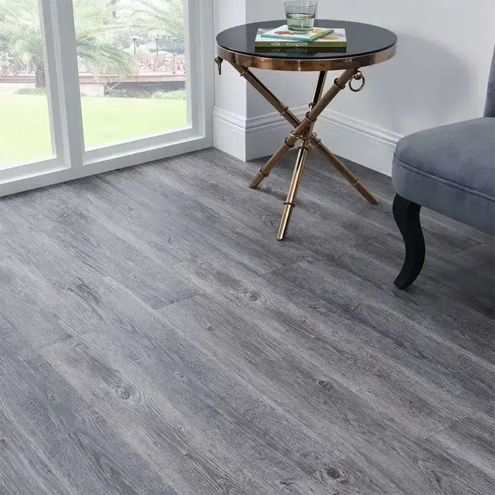 Un piso de madera gris con una mesa y una silla en una sala de estar.