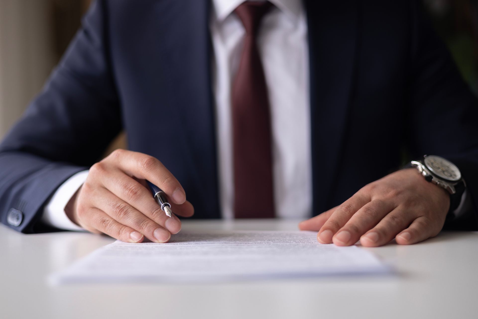 Man signing divorce papers with support from a divorce lawyer for men during a legal consultation. Man signing divorce papers with support from a divorce lawyer for men during a legal consultation.