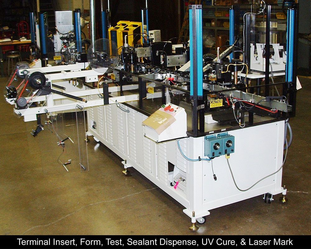 A machine that is labeled terminal insert form test sealant dispense uv cure & laser mark