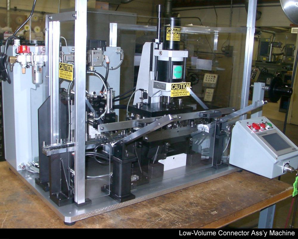 A machine that says low volume connector assy machine on it