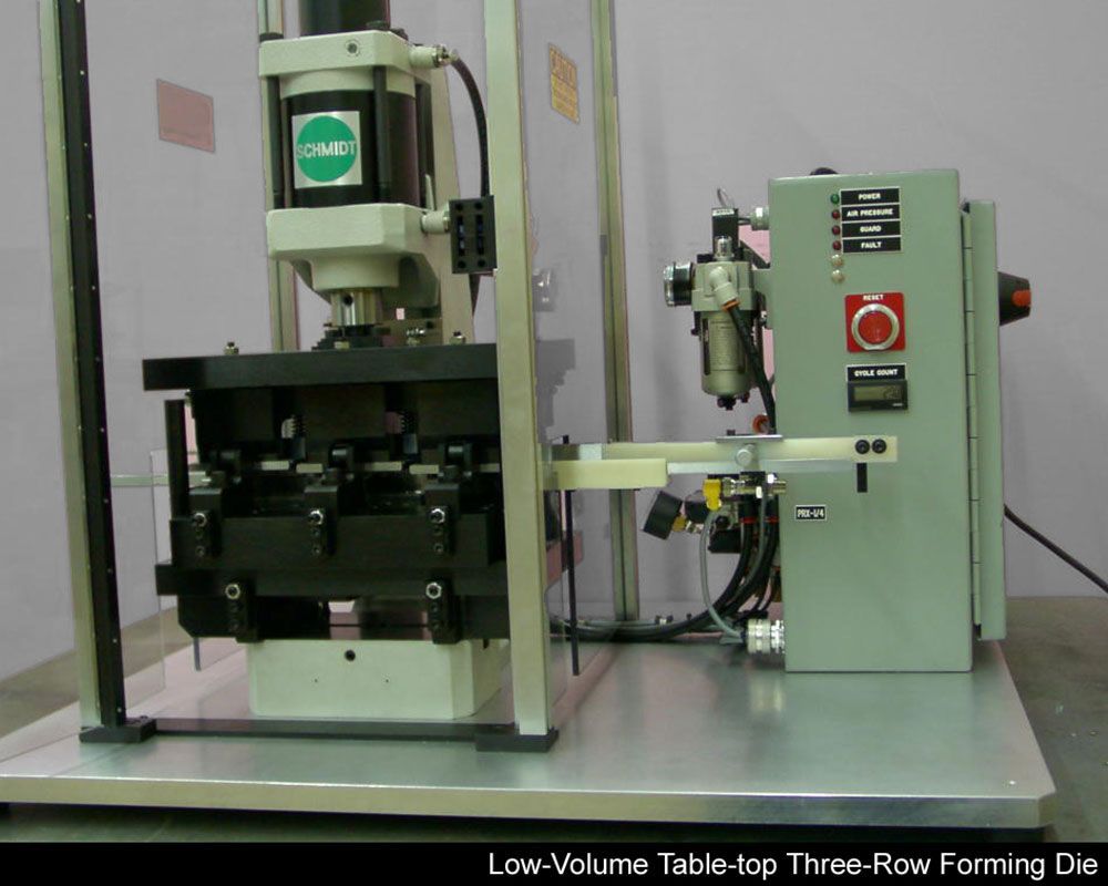 A machine that is labeled low volume table top three row forming die