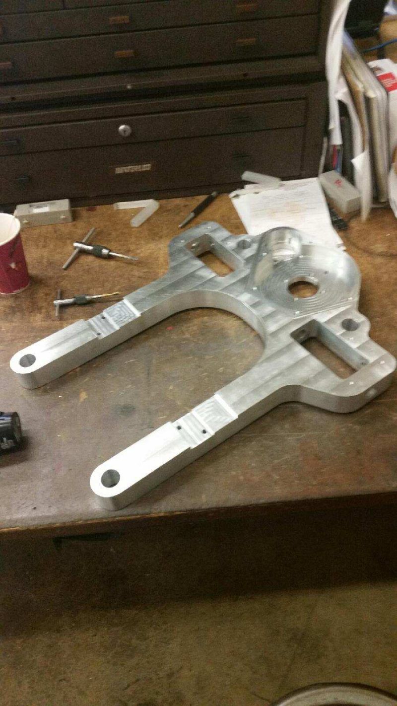 A piece of metal is sitting on top of a wooden table.