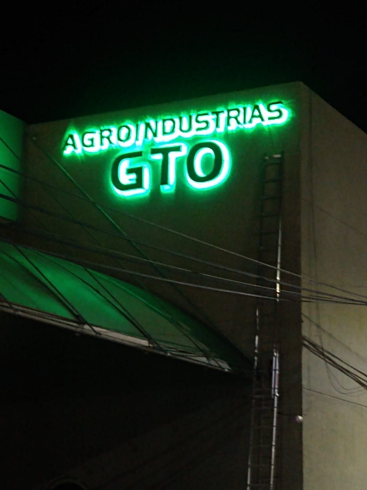 Un cartel de Agro Industrias GTO se ilumina por la noche.