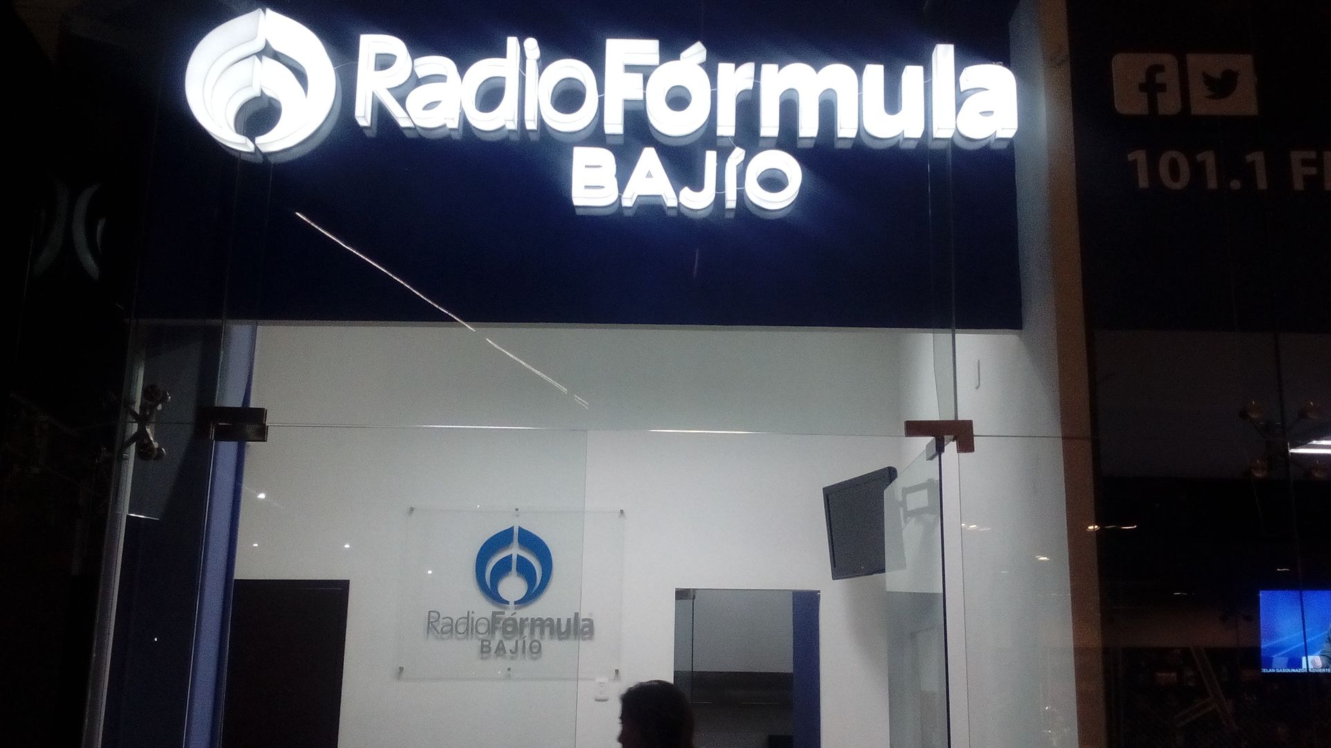 Un cartel de Radio Fórmula Bajo se ilumina por la noche.