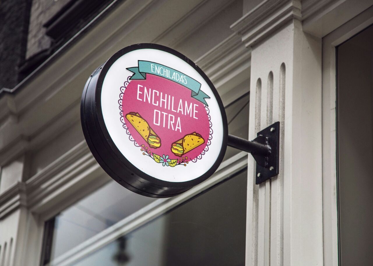 Un cartel al costado de un edificio que dice enchilame otra