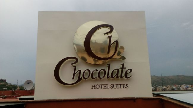 Un cartel que indica las suites del hotel de chocolate está en la parte superior de un edificio.