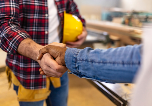 A photo of a deck contractor and a customer shaking hands to confirm a successful deck project.