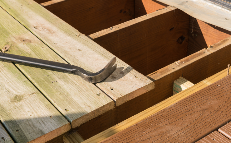 A photo of a deck that Pacific Peak Decks is repairing. They are removing old wooden deck boards and replacing them with durable composite materials.