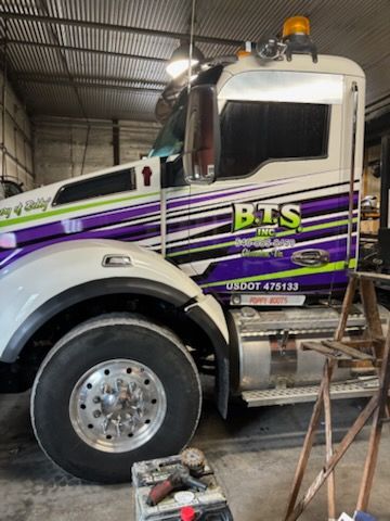 A man is standing in front of a pile of scrap metal.