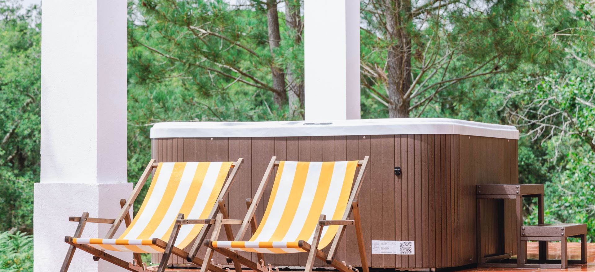 Two yellow and white striped chairs are sitting next to a hot tub.