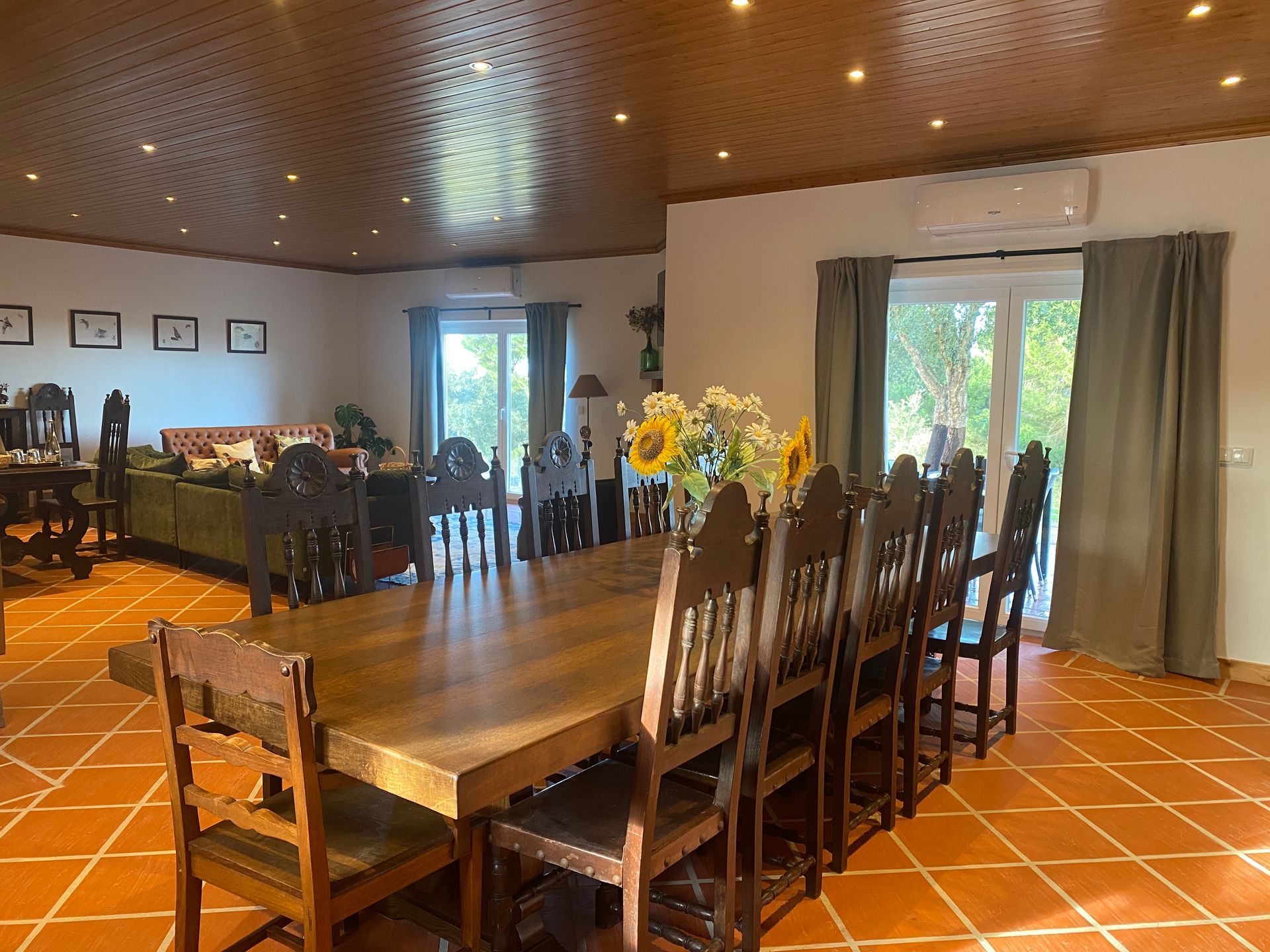 A large dining room with a long wooden table and chairs.