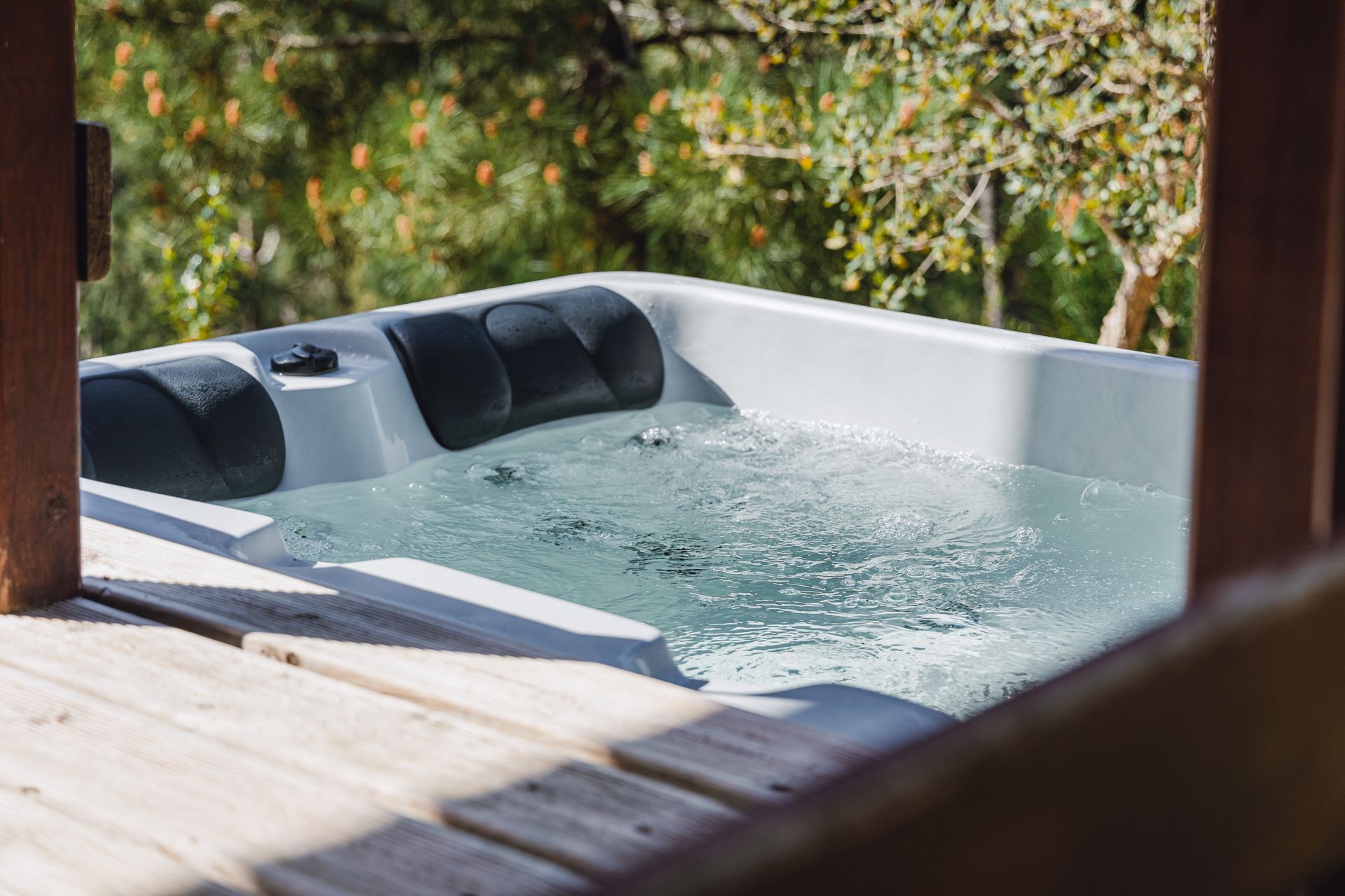 A hot tub is sitting on top of a wooden deck.