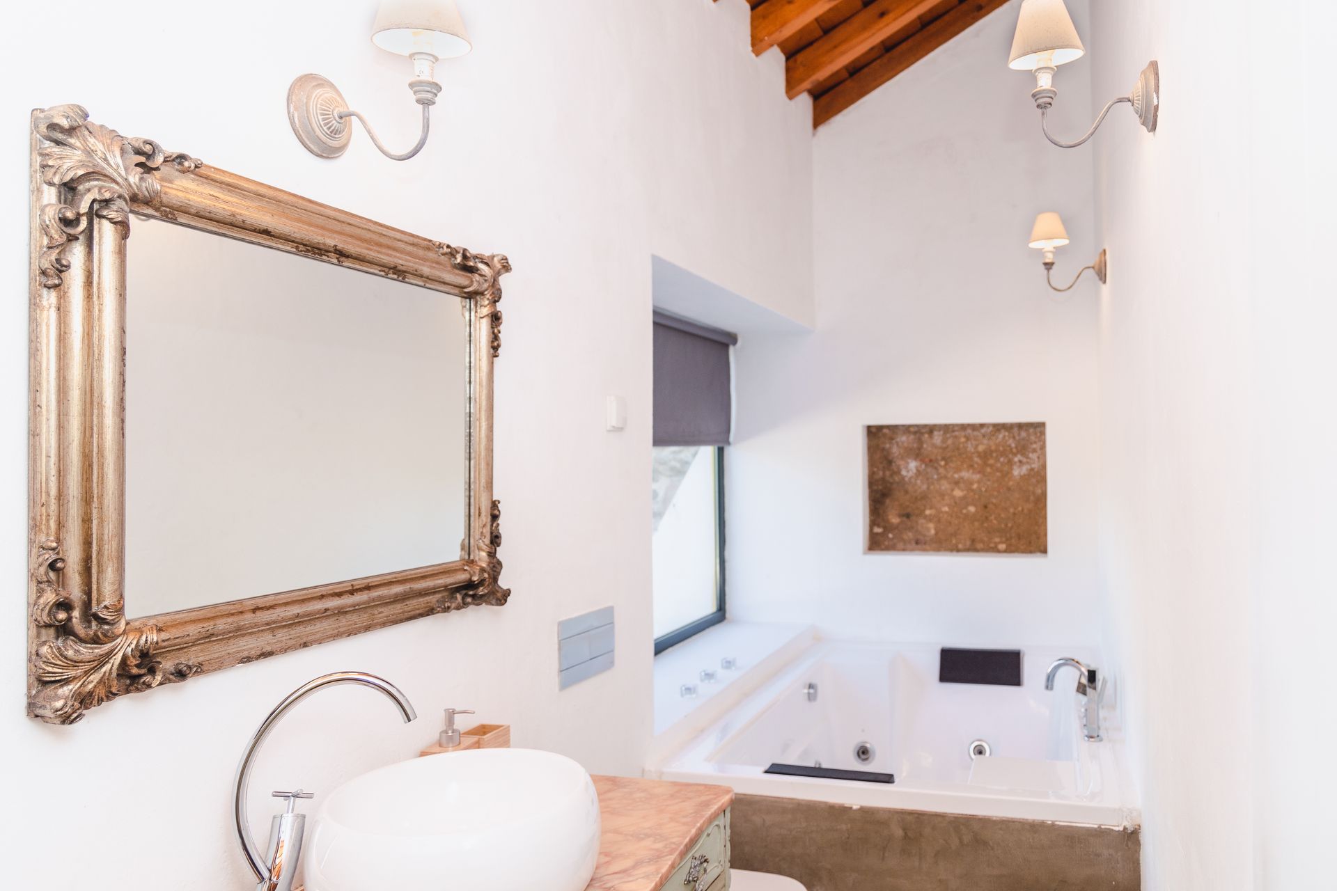 A bathroom with a sink , mirror and bathtub.