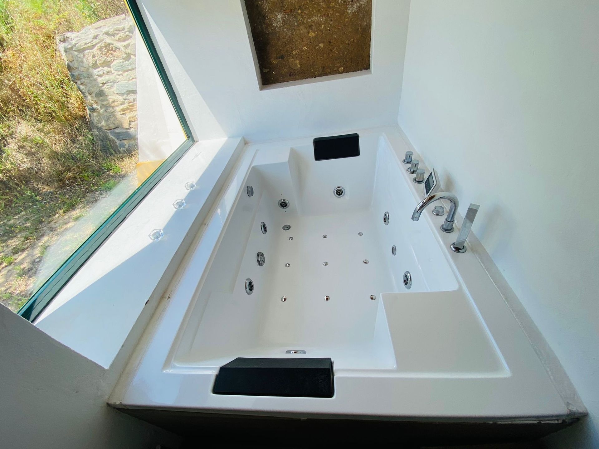 A white bathtub with a window in the background
