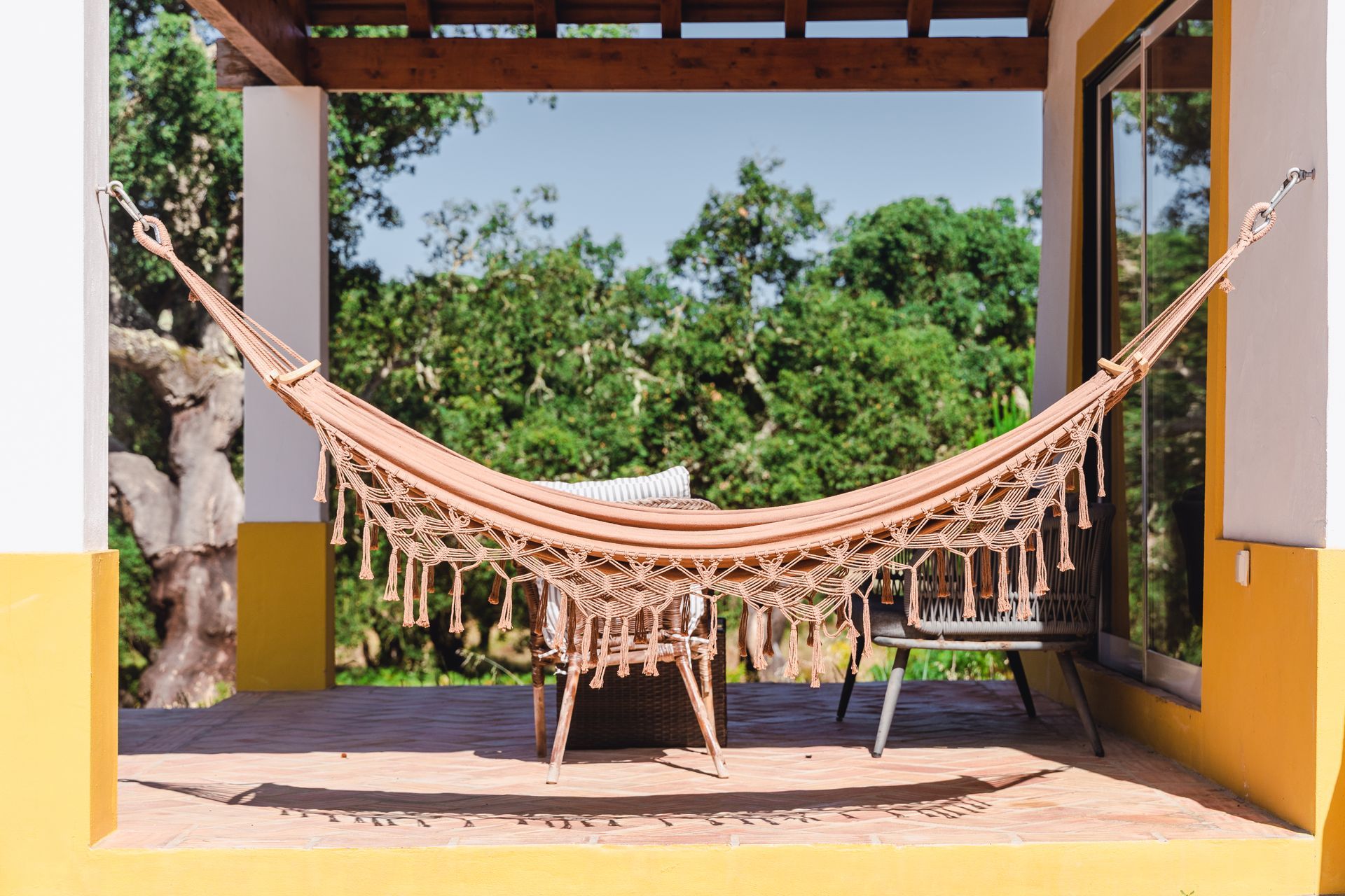 A hammock is hanging from the side of a building.