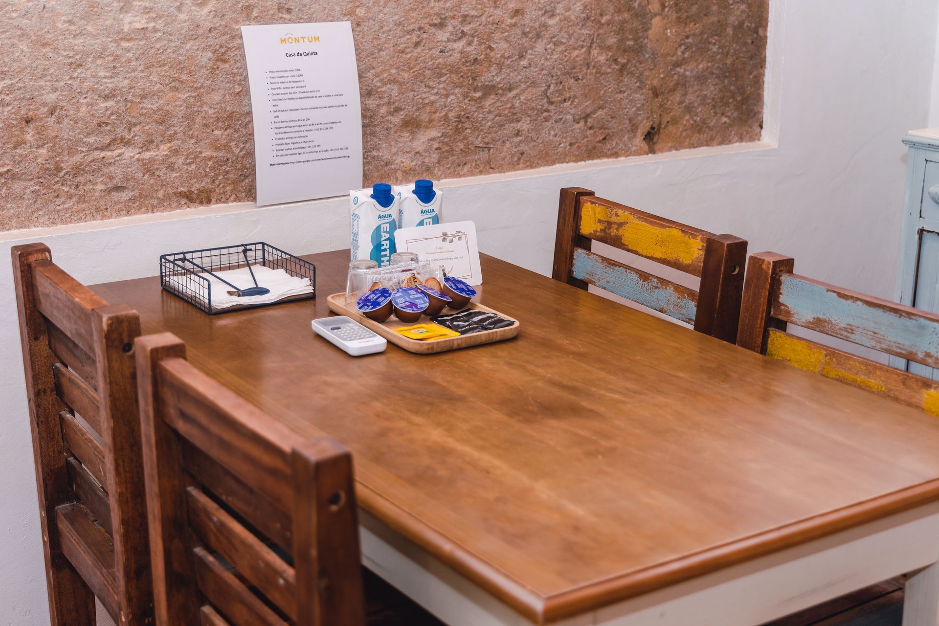 A wooden table with two chairs and a tray of food on it.