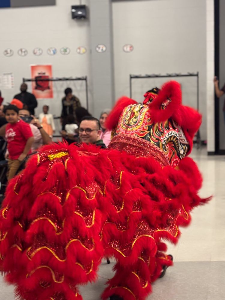 A man in a red costume is dancing in front of a crowd.