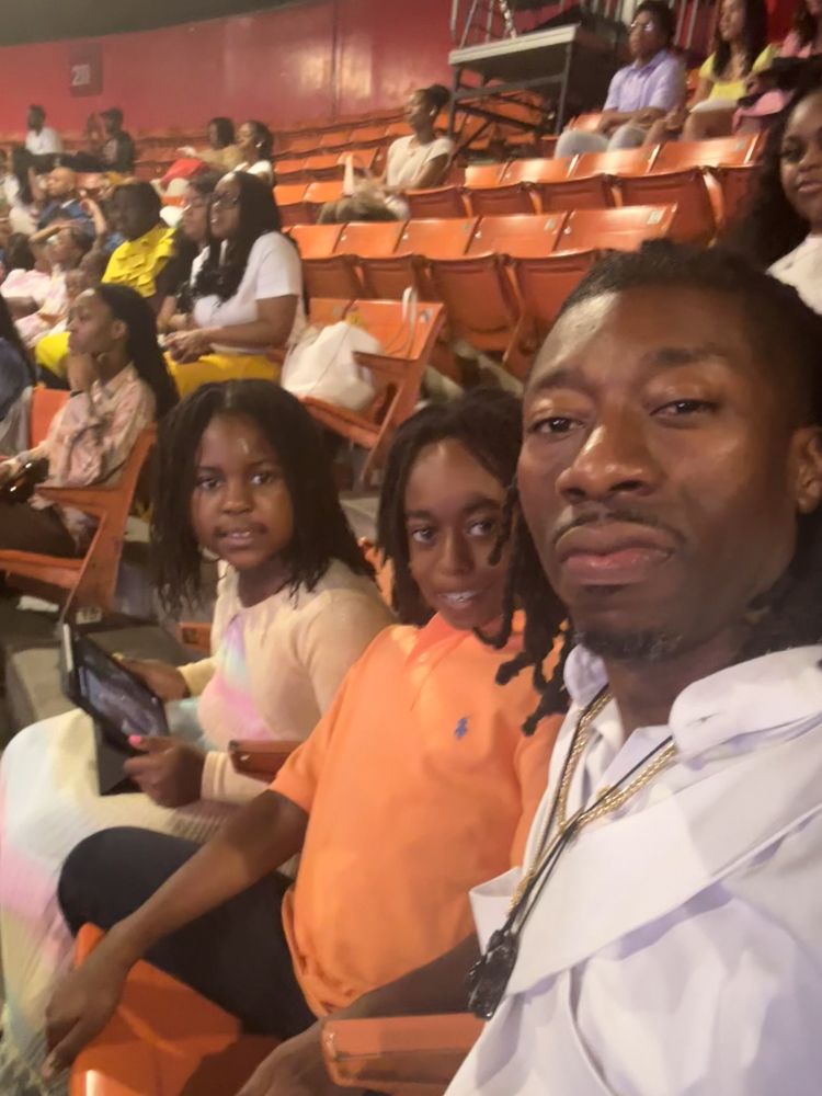 A group of people are sitting in a stadium watching a game.
