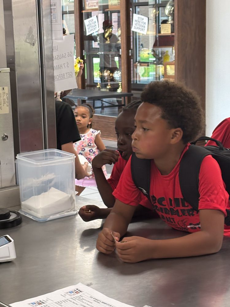 A group of children are sitting at a counter in a restaurant.