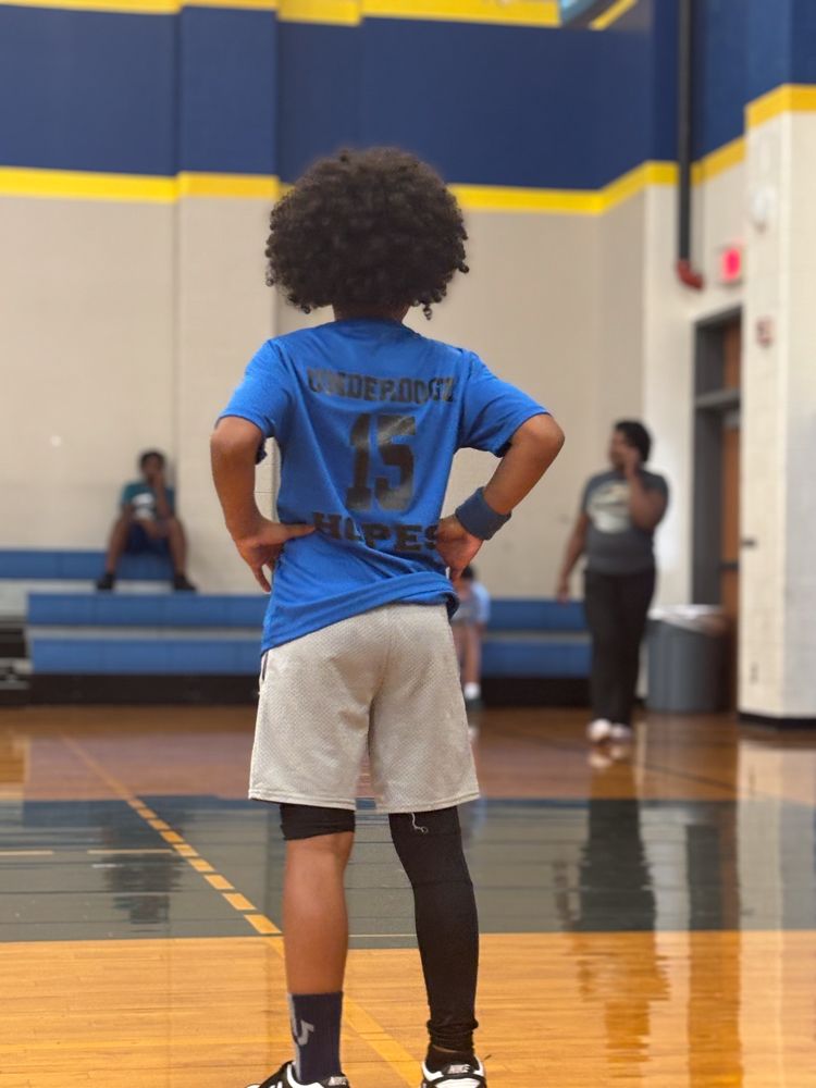 A boy wearing a blue shirt with the number 15 on it