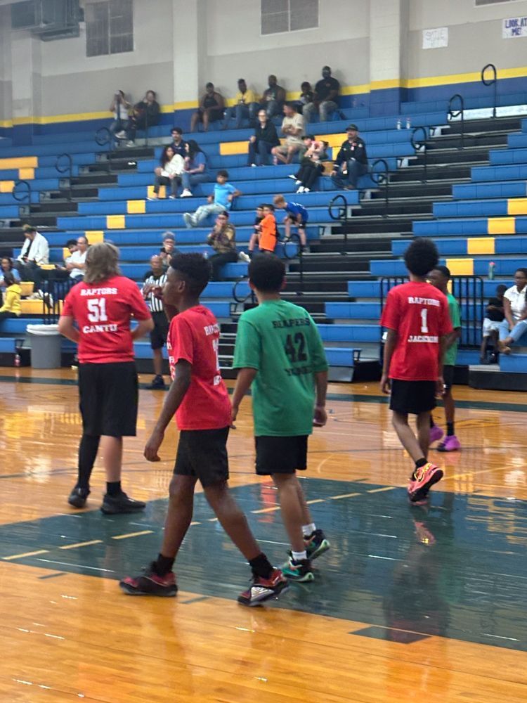 A group of young boys are playing basketball in a gym.
