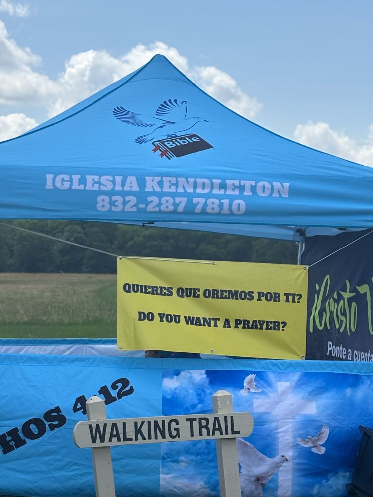 A blue tent with a sign that says walking trail