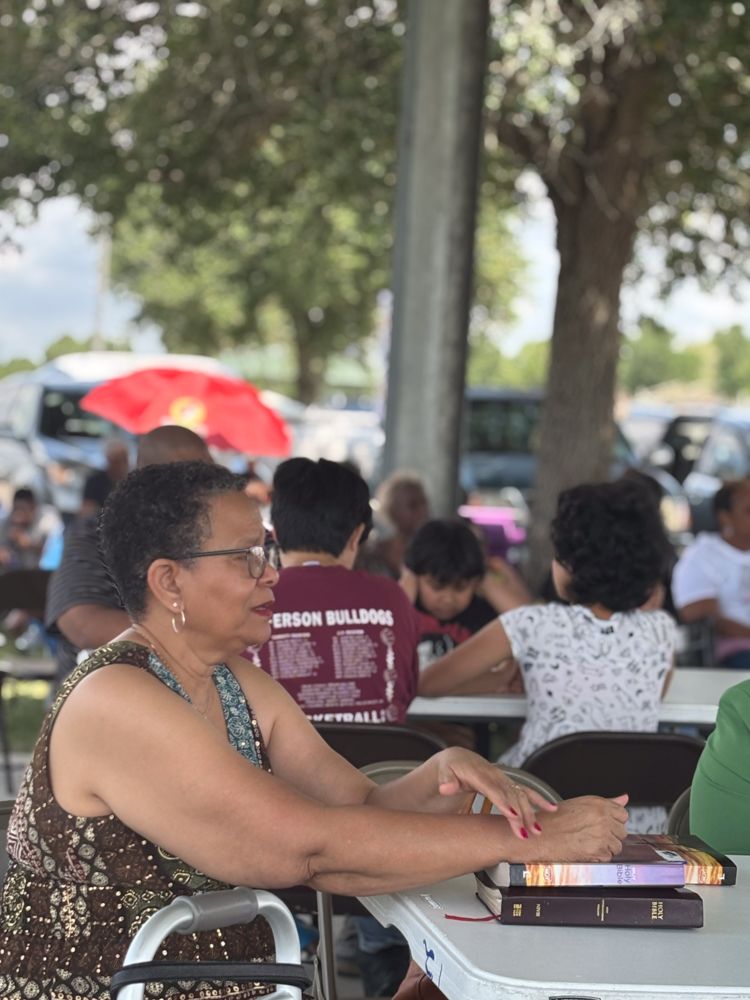 A woman in a wheelchair is sitting at a table with a bible.