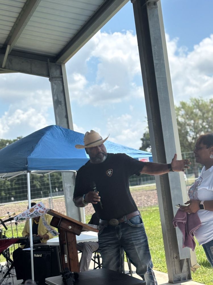 A man in a cowboy hat is standing at a podium giving a speech.